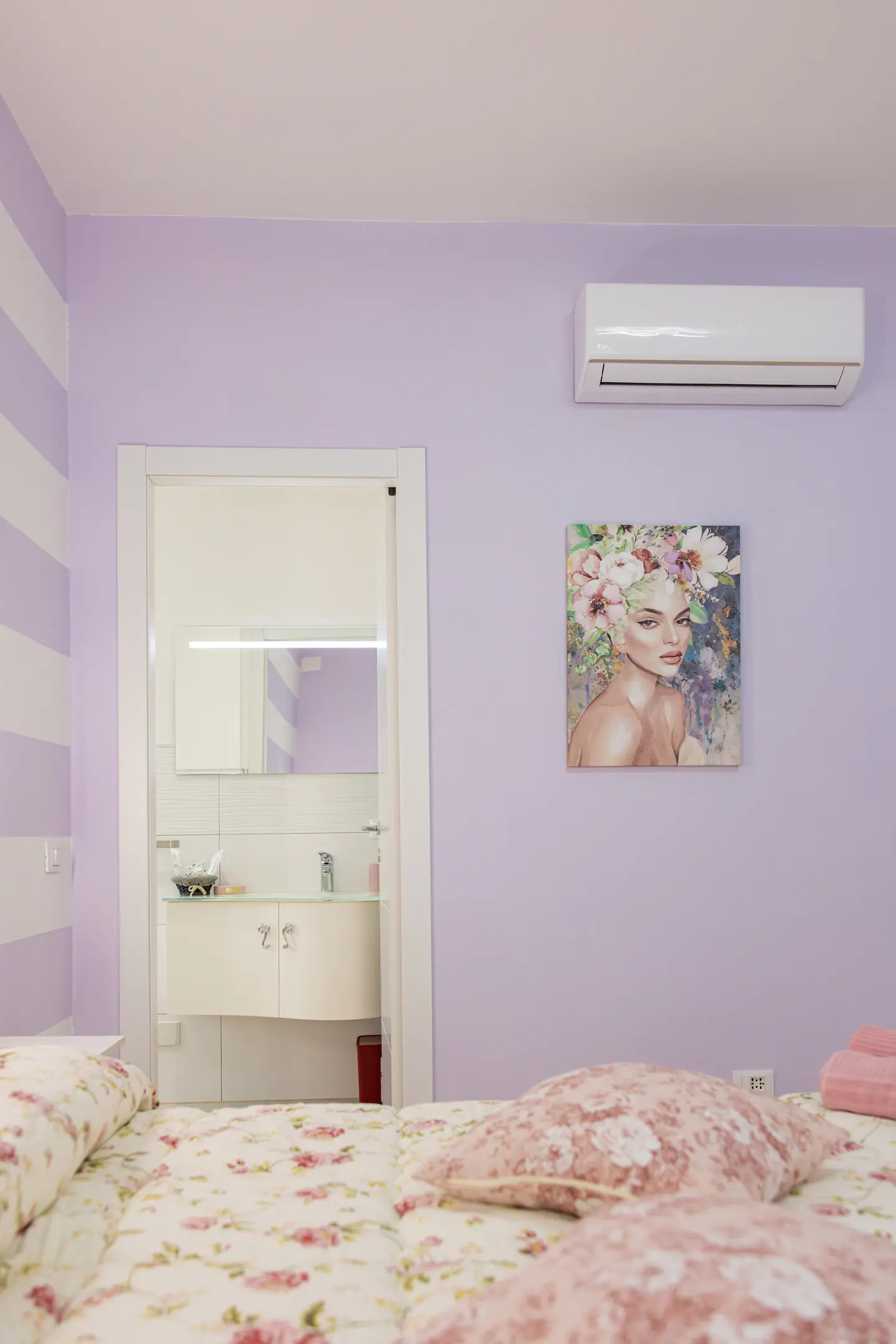 Angolo della camera con stampa floreale e porta del bagno privato